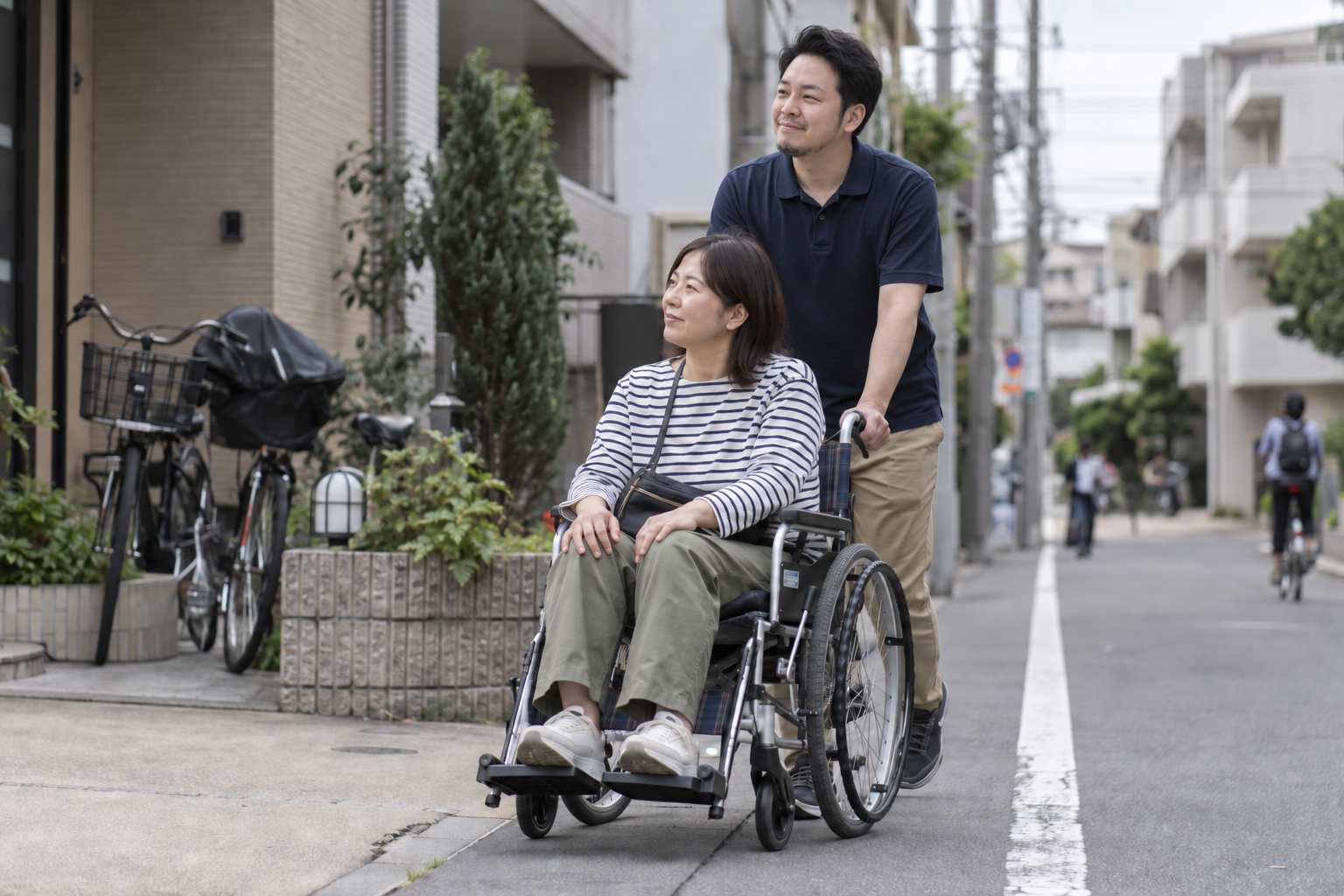 住宅街で車いすを使う女性の外出に付き添う場面(支援内容を表したイメージ)