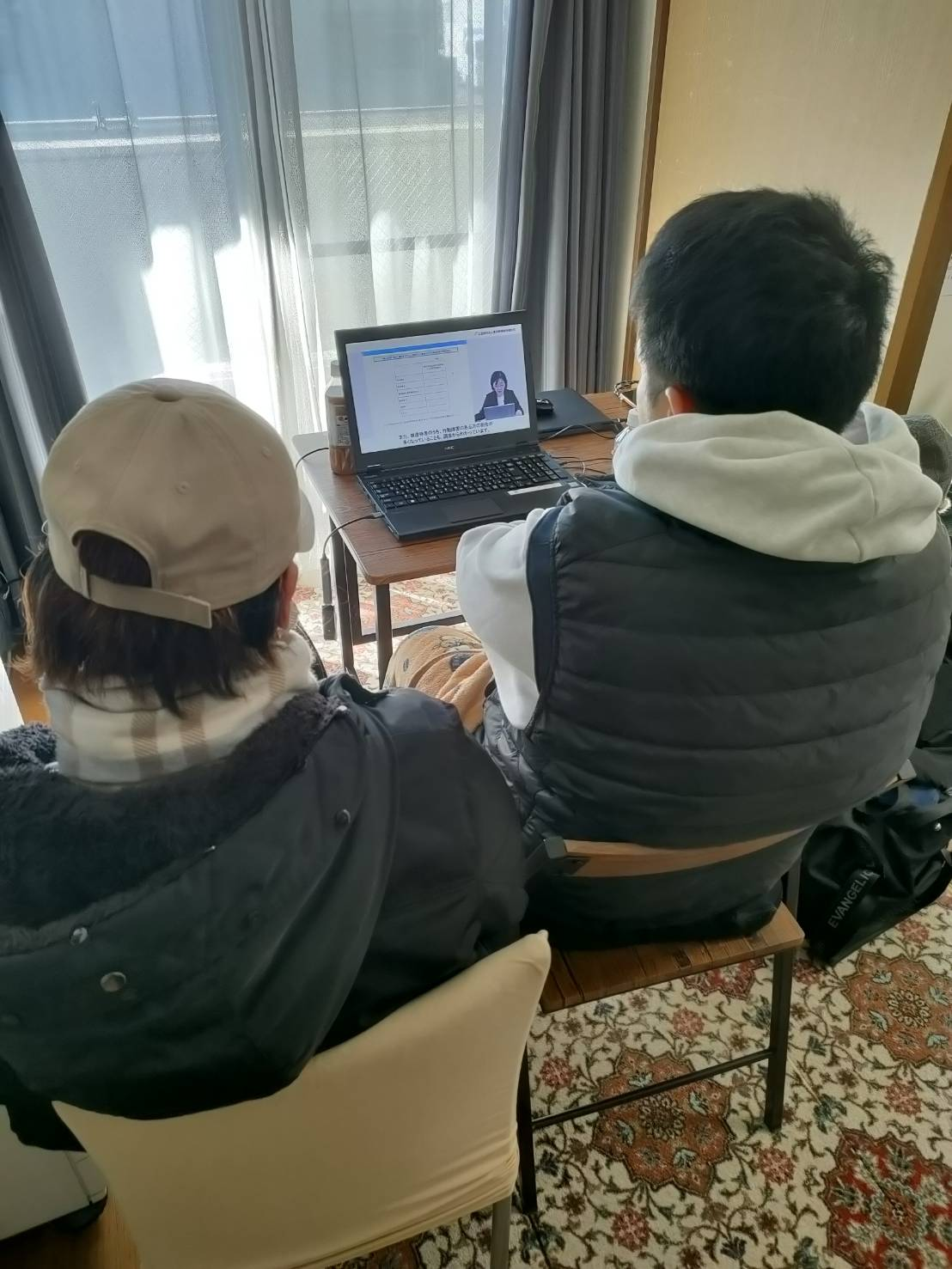 スタッフが並んで研修映像を見ている様子