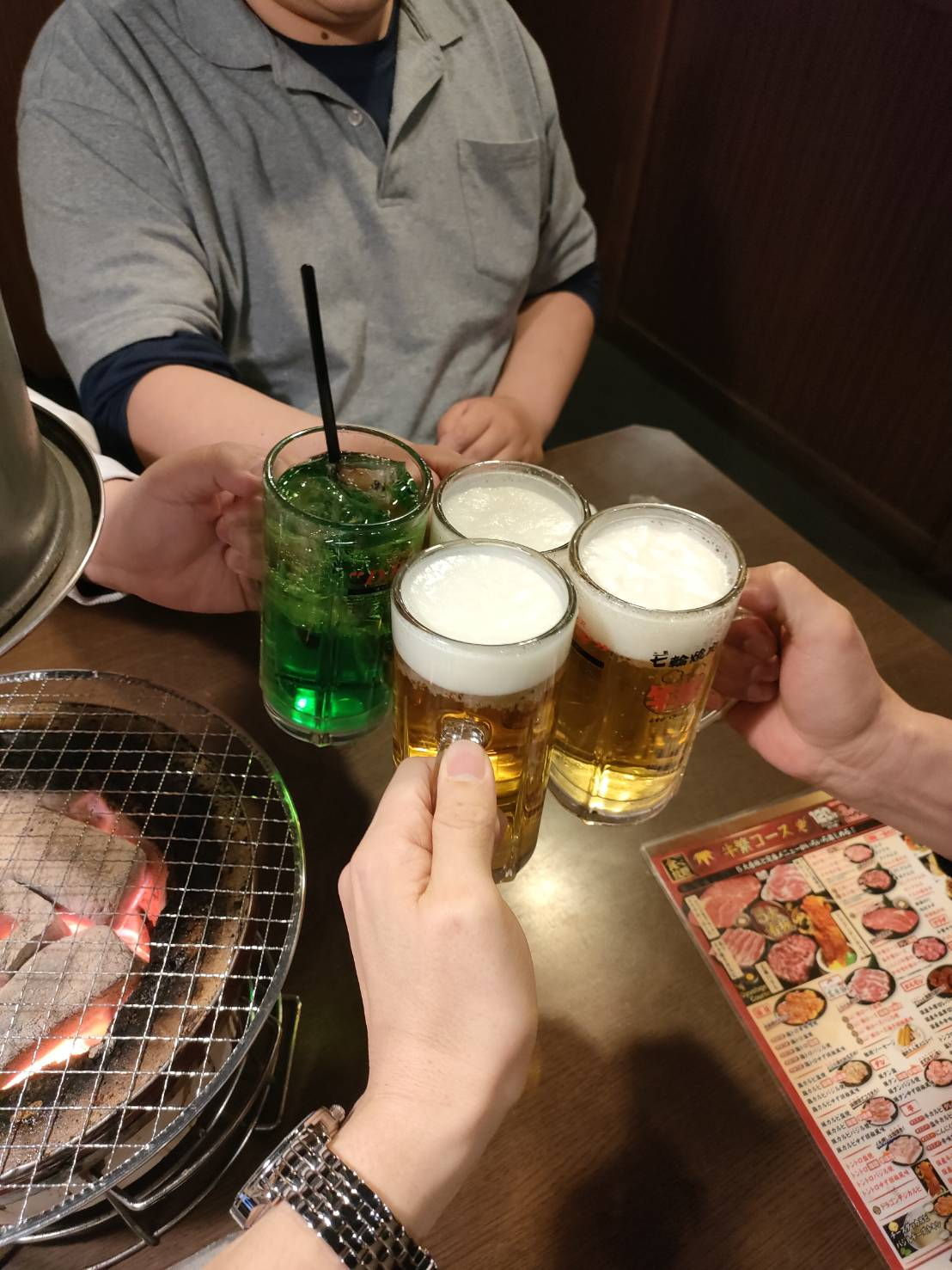 交流会で飲み物を手に乾杯するスタッフの手元